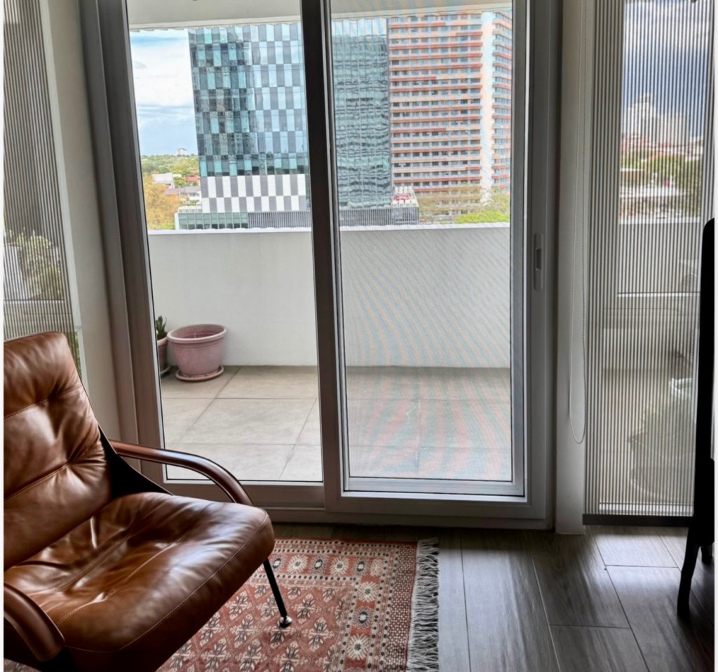 Full-height sliding glass door leading to the balcony at The Mondrian Residences 1-bedroom unit