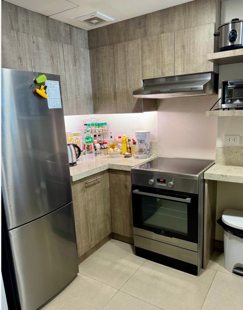 Renovated kitchen with induction cooktop and rangehood at The Mondrian Residences 1-bedroom unit